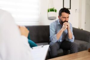 man sitting on couch in an anxiety treatment program