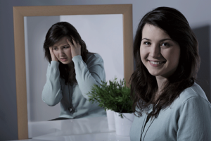 woman smiling but also unhappy considering a bipolar disorder treatment program