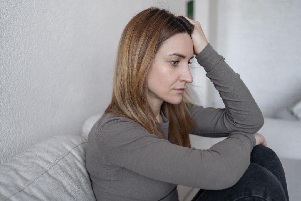 woman on couch considers the signs of heroin abuse