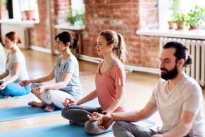 people sitting on yoga mats in meditative therapy