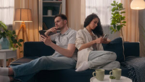 Man and woman searching on their phone how to stop being addicted to social media.