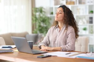 Woman taking a deep breath after learning mindfulness based cognitive therapy techniques.